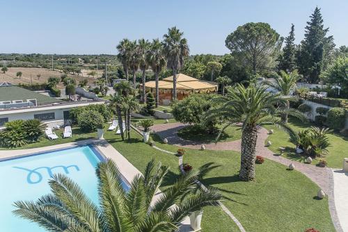 vista aerea di un resort con piscina e palme di Hotel Villa Maria a Crispiano