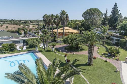 an aerial view of a resort with a swimming pool and palm trees at Hotel Villa Maria in Crispiano