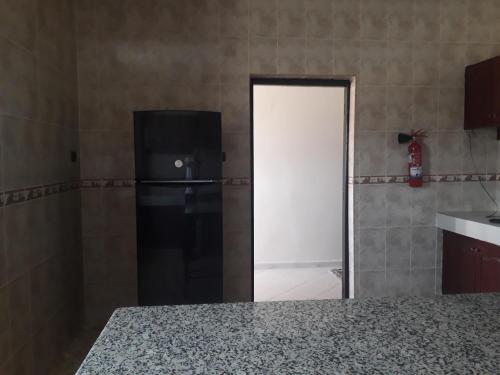 a kitchen with a black refrigerator and a door at Almounia Hotel & Spa in Taroudant