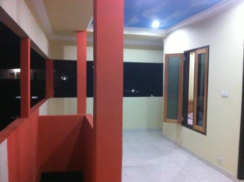 a room with a red staircase in a house at Blue Shark Divers Bunaken in Bunaken