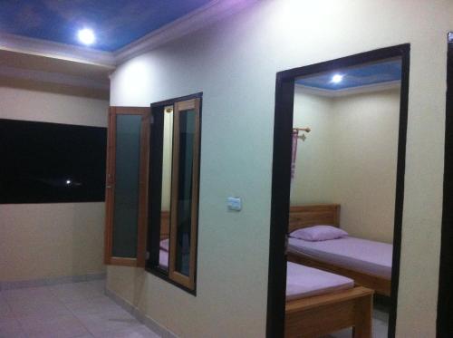 a room with two beds and a mirror at Blue Shark Divers Bunaken in Bunaken