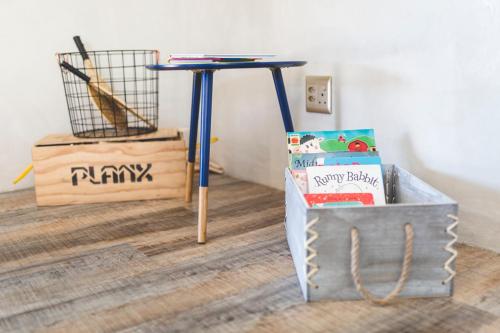 a blue table with a bag of food and a box of books at The Farmstead in Franschhoek