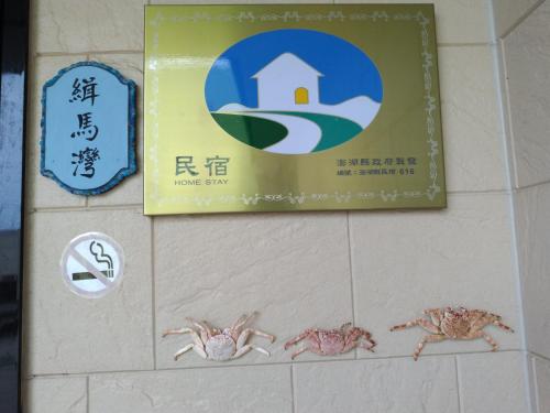 a sign on a wall with crabs on it at Jama Bay in Xiyu