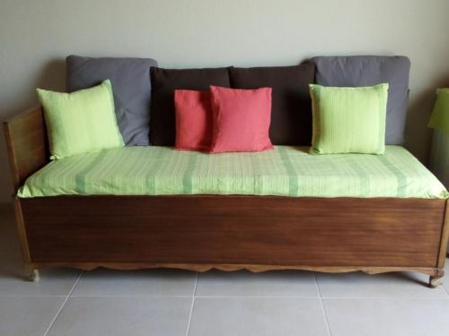 a futon bed with four colorful pillows on it at Blackmountain Sea Spot in Mavrovoúnion