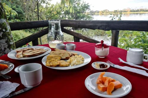 una mesa con platos de comida en un mantel rojo en Eware Refugio Amazonico en Puerto Nariño