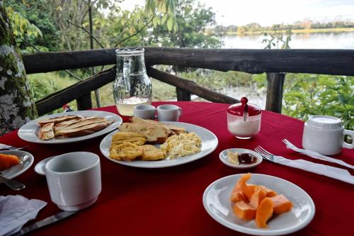 a table with plates of food on a red table cloth at Eware Refugio Amazonico in Puerto Nariño