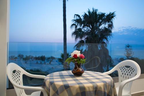 a table with a vase of flowers on top of it at Irene Studios in Mastichari