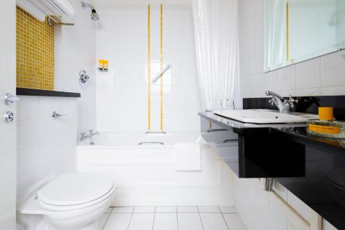 Baño blanco con aseo y lavamanos en Dingle Bay Hotel, en Dingle