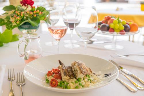 a plate of food on a table with wine glasses at Das-Schmidt Privathotel in Mörbisch am See