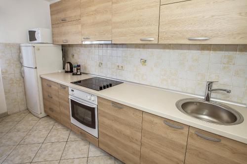 a kitchen with a sink and a refrigerator at Apartments Juranić in Baška