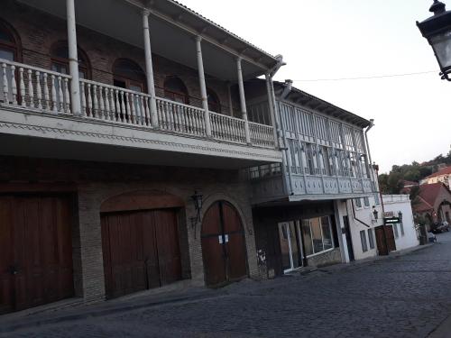 a building with a balcony on the side of a street at MANGO Guesthouse in Sighnaghi