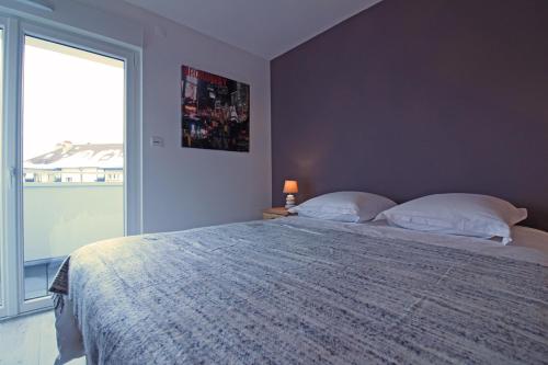 a bedroom with a large bed and a large window at "Chez Suzèle" in Gérardmer