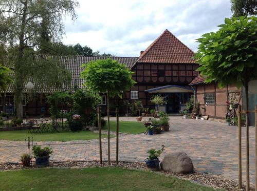 a courtyard of a house with trees and a building at Separate Gästewohnung in Plockhorst