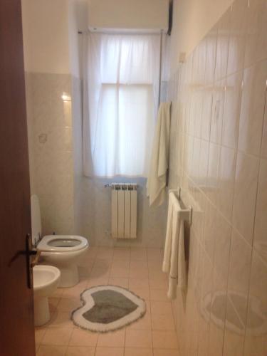 a bathroom with a toilet and a shower with a window at Casa della nonna in Riposto