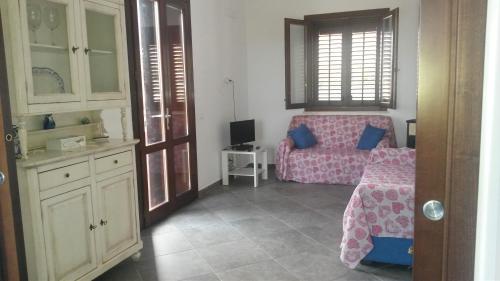 a living room with a pink couch in a room at Villa Cloe in San Vito lo Capo