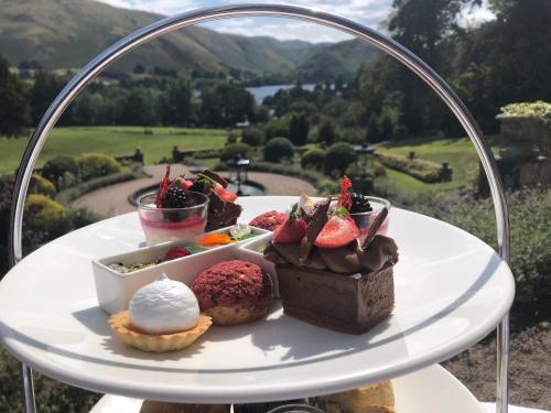a plate of desserts on a table with a view at Macdonald Leeming House in Watermillock