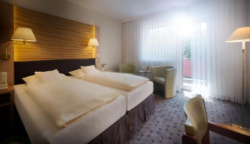 a hotel room with a large bed and a window at Hotel Sonneneck in Bad Kissingen