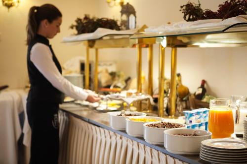 a woman standing in front of a counter filled with plates of food at Villa Jerez in Jerez de la Frontera