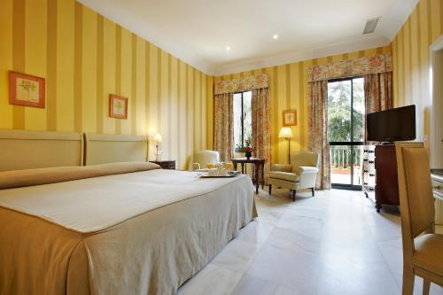 um quarto com uma cama grande e uma televisão em Villa Jerez em Jerez de la Frontera