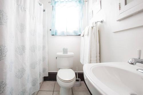 a bathroom with a toilet and a tub and a sink at New Orleans Hideaway in New Orleans