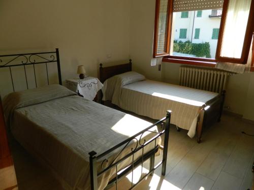two beds in a room with a window at Villa Ester in Camaiore