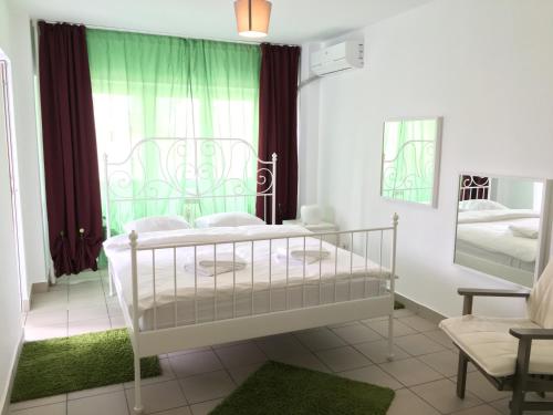 a bedroom with a white bed and a window at Green Apartment 6 in Bucharest