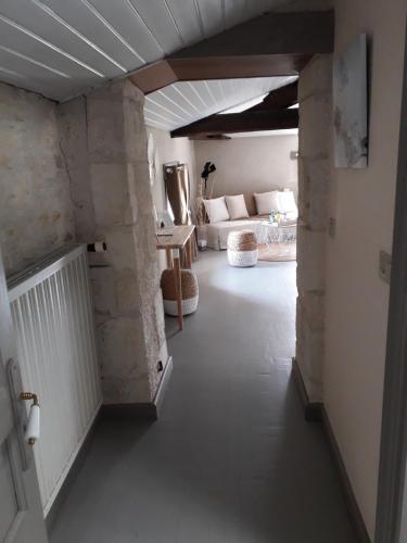 a hallway with a living room with a couch and a room with at Le Marais Picotin in Saint-Pierre-le-Vieux