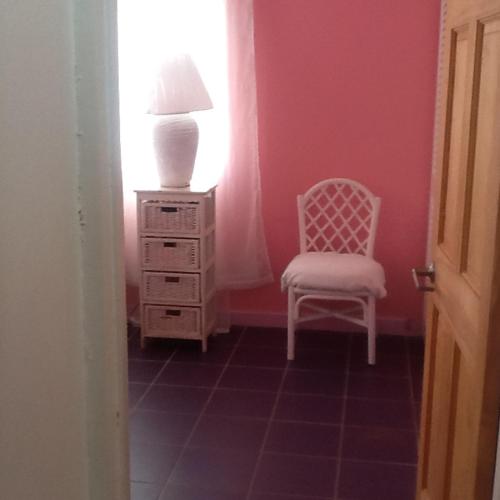 a room with a chair and a lamp and a dresser at A Private Room in Paradise, Vieux Fort in Vieux Fort