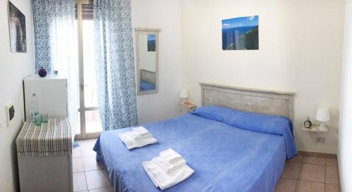 a bedroom with a blue bed with two towels on it at Blu Rooms Marettimo in Marettimo