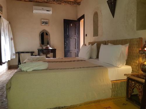 a bedroom with a large bed in a room at Kasbah La Cigogne in Aït Ben Haddou