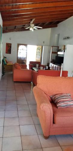 a living room with red couches in a room at A Private Room in Paradise, Vieux Fort in Vieux Fort