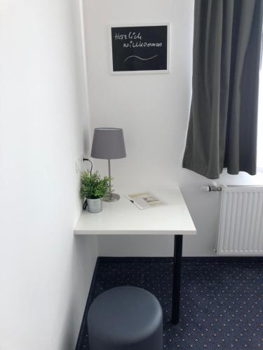 a desk in a room with a chair and a lamp at Pension Tennisweber in Schwechat