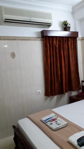 a room with a bed and a window with a curtain at Grand View Residency Chennai in Chennai