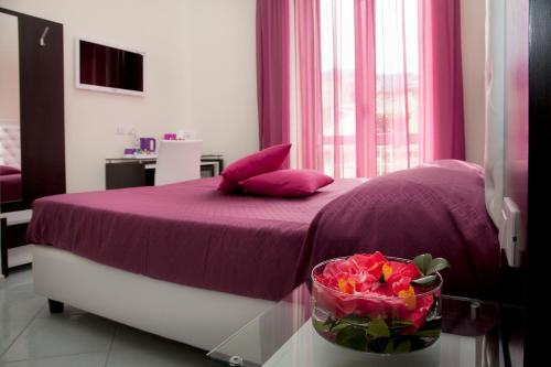 a bedroom with a purple bed with a bowl of flowers at Sorrento Flats in Sorrento