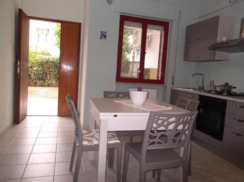 ポリコーロにあるCasa Vacanze Afroditeのキッチン(白いテーブル、椅子、テーブル付)