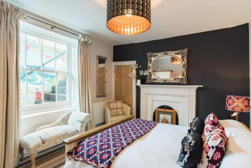 a bedroom with a bed with a fireplace and a mirror at CWTCH APARTMENT by the sea in Aberystwyth