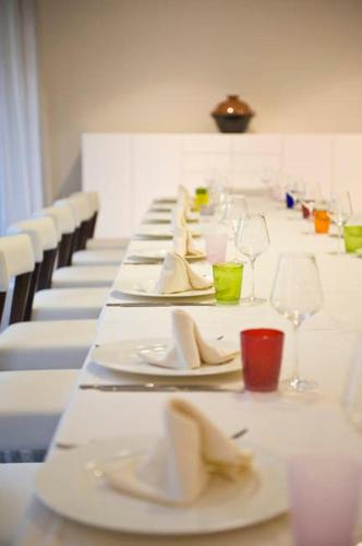 a long table with white plates and wine glasses at Palazzo Virgilio in Brindisi