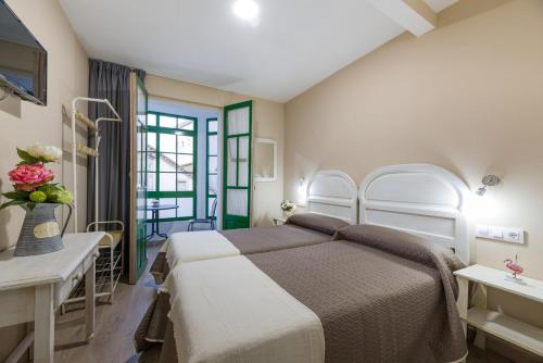- une chambre avec un lit, une table et une fenêtre dans l'établissement Pensión Luis, à Arzúa