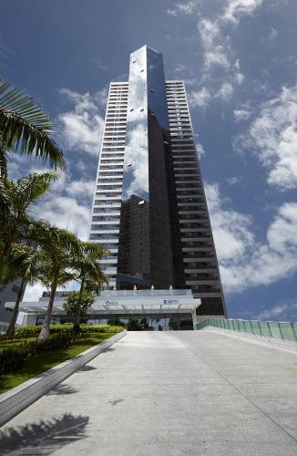 a large tall building with a palm tree in front of it at Transamerica Prestige Recife - Boa Viagem in Recife