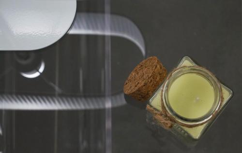 a glass jar of green liquid and a piece of bread at Galleria 38 in La Spezia