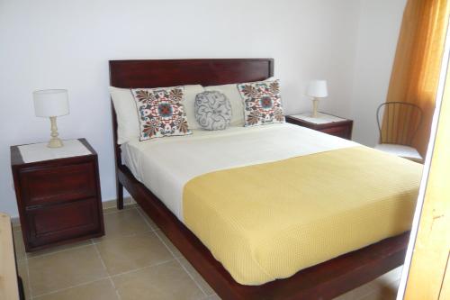 a bedroom with a large bed with two night stands at Pez 106 in Bayahibe