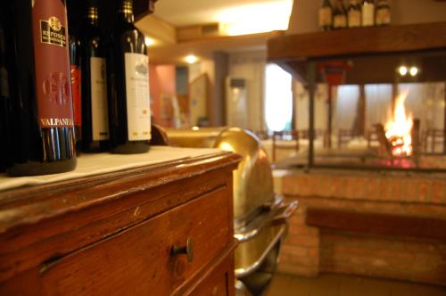 a counter with bottles of wine on it with a fireplace at Hotel Belie in San Martino di Lupari
