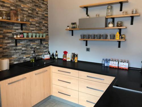 a kitchen with a black counter top and wooden cabinets at Vila Pod Zámkem Lednice in Lednice