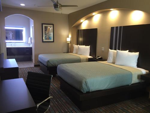 a hotel room with two beds and a desk at Econo Lodge Inn & Suites Houston NW-Cy-Fair in Houston