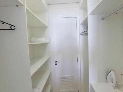 a white bathroom with a toilet and a closet at Landscape in Fortaleza