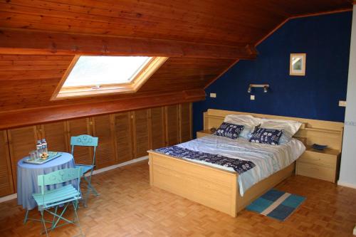 sypialnia z łóżkiem, oknem i stołem w obiekcie Au Fil des Rêves w mieście Rèves