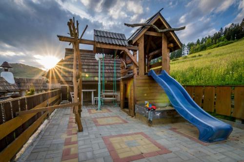 a playground with a slide and a house at Chata Katka in Dolný Kubín