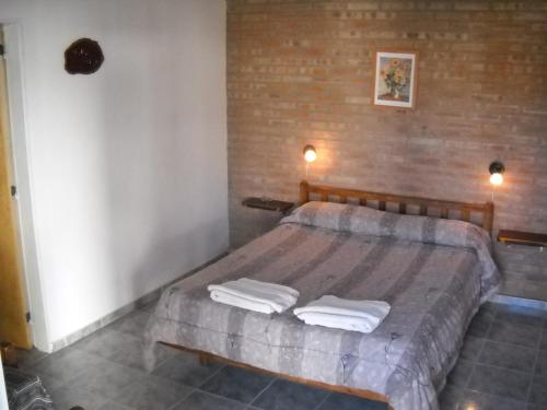 1 dormitorio con 1 cama grande y toallas. en Hosteria Nido de Condores en Mina Clavero