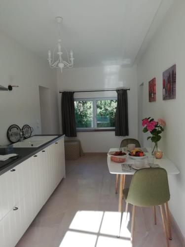 une cuisine avec une table et des chaises dans une pièce dans l'établissement Liz'A logis de Charme, à Saint-Côme-de-Fresné