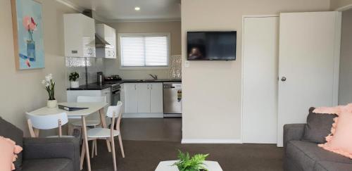 a kitchen and living room with a couch and a table at Rose Apartments Unit 3 Central Rotorua - Accommodation & Spa in Rotorua